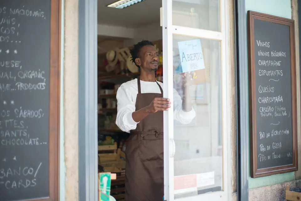 Comerciante abre a porta da loja no início do expediente