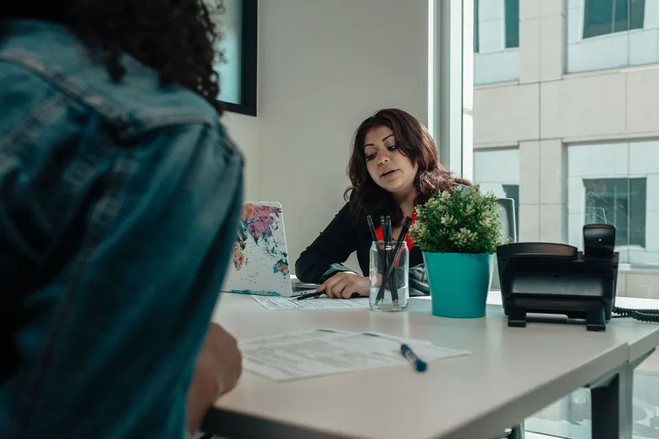 Profissional confere documentos com a cliente à mesa
