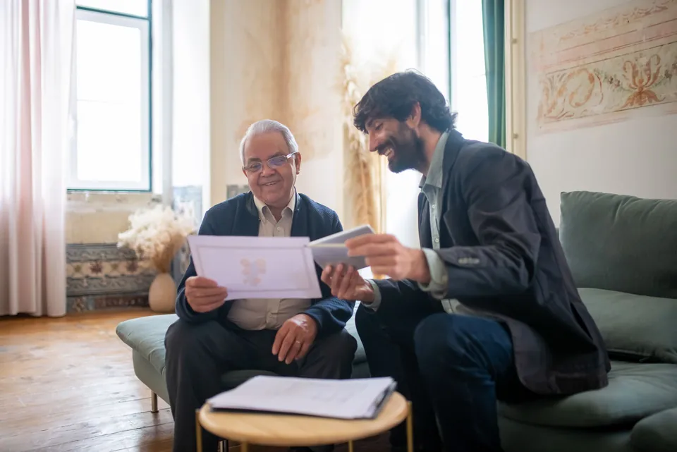 Duas pessoas leem um documento impresso lado a lado