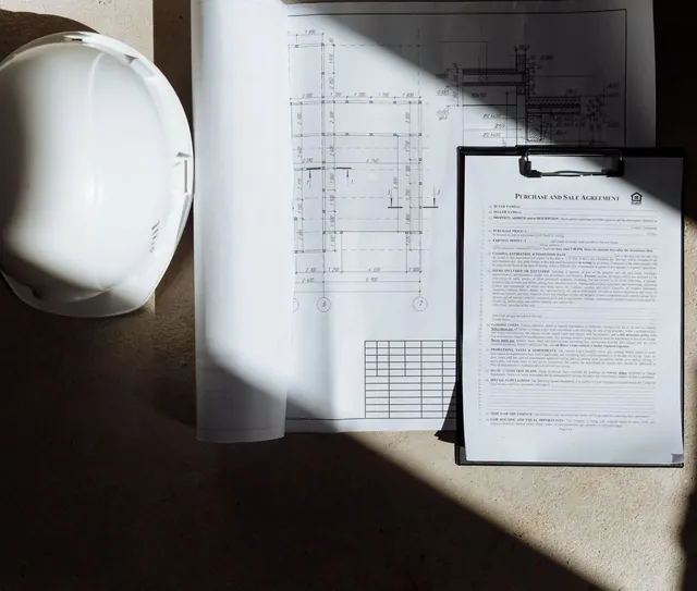 Capacete de segurança, prancheta e projeto sobre a mesa