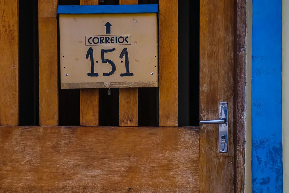 Portão de madeira de uma casa, com a caixa de correspondência