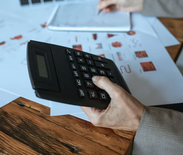Mão usa a calculadora sobre extratos e relatórios