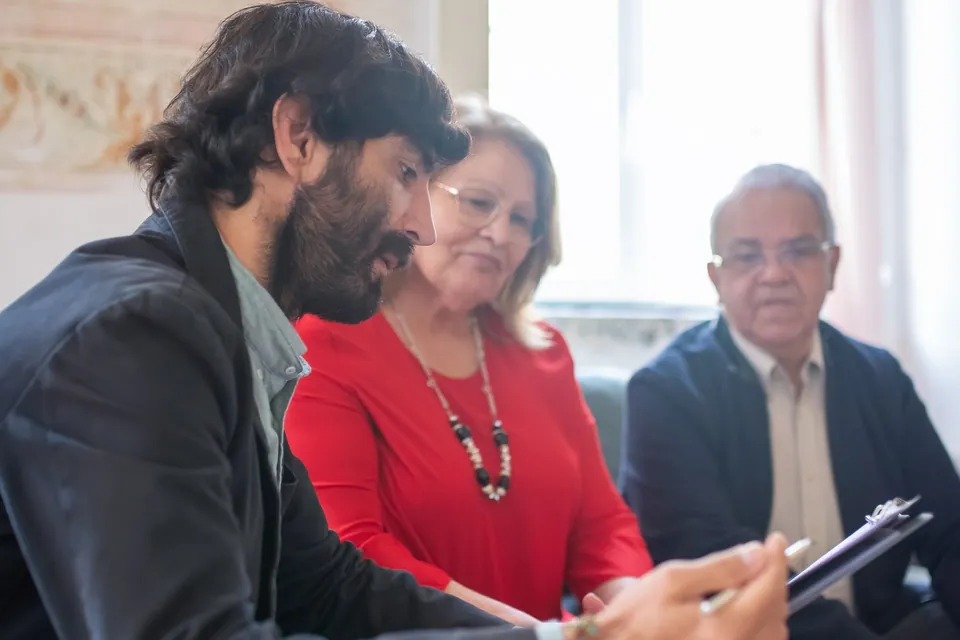 Profissional conversa com um casal sobre documentos