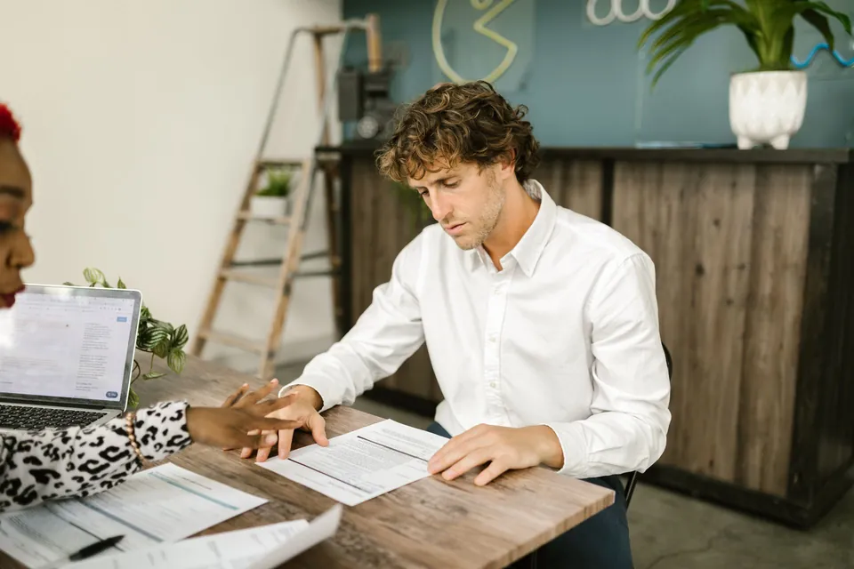 Profissional aponta uma cláusula do contrato para o cliente