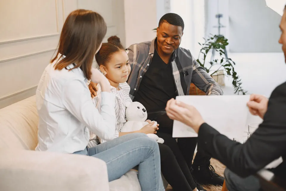 Pai, mãe e a filha pequena conversam com um profissional