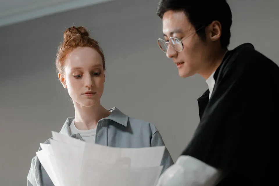 Duas pessoas conferem certidões impressas