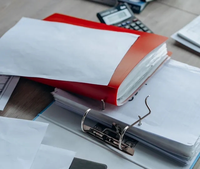Pastas e documentos organizados sobre a mesa de trabalho