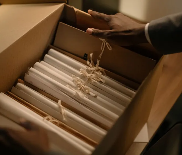 Caixa com os documentos separados em pastas, sobre a mesa