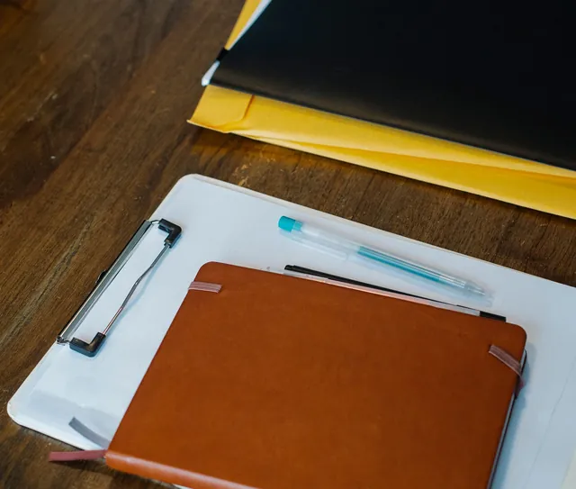 Prancheta, agenda e folhas em branco sobre a mesa