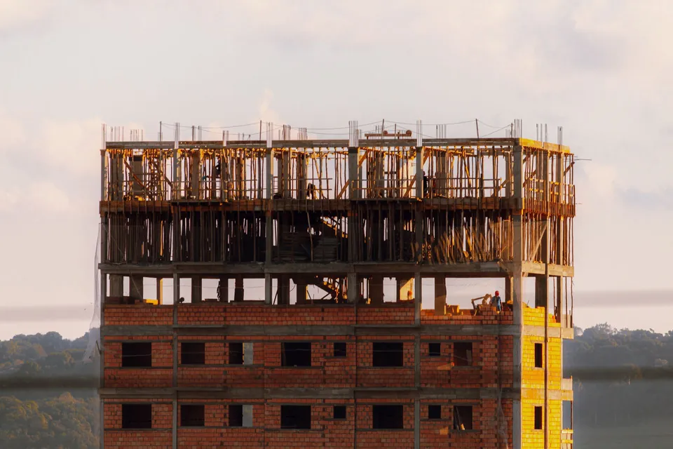 Prédio residencial em obra, com laje e alvenaria ainda aparentes