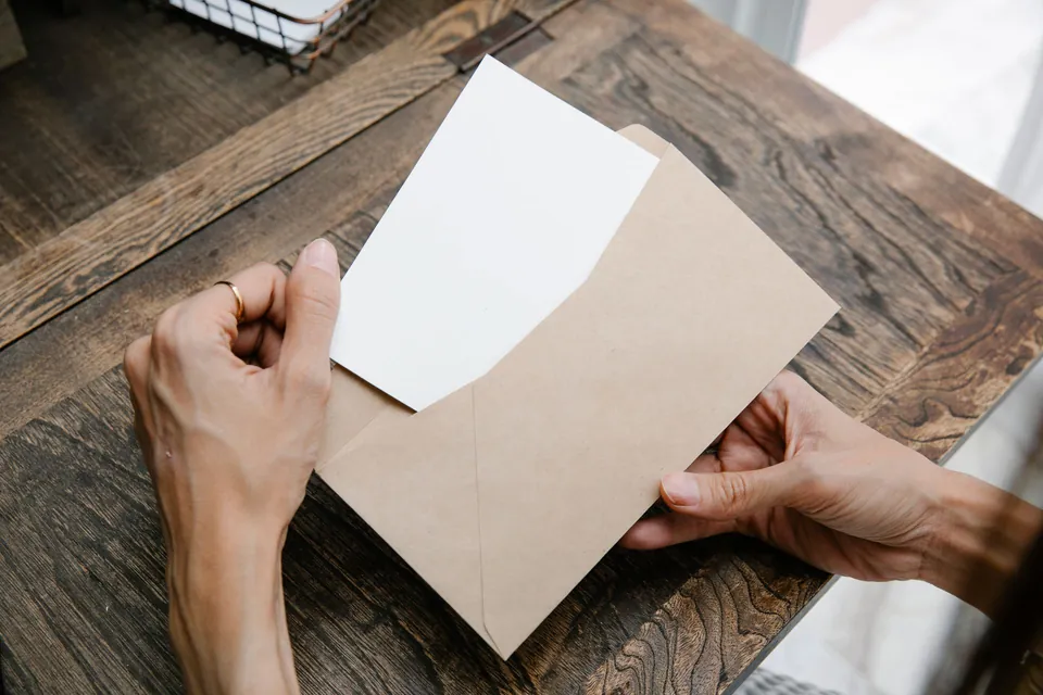 Mãos abrem um envelope com a correspondência